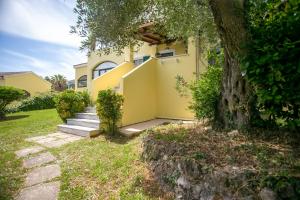 a yellow house with stairs and a tree at Casa Govino - Dolce fare niente in Danilia