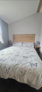 a bedroom with a bed with a bedspread with butterflies on it at T&K's Caravan in Morecambe