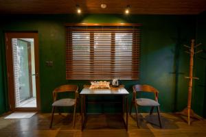 a dining room with green walls and a table and chairs at Aran Villas in Santa Maria