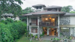 a large white house with a balcony at Surf Range in Matara