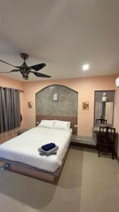 a bedroom with a bed and a ceiling fan at Myhomevillage in Ko Tao