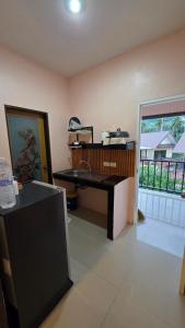 a kitchen with a desk in a room with a window at Myhomevillage in Ko Tao