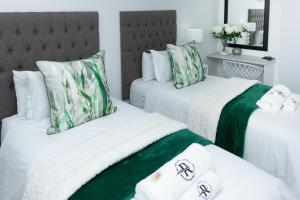 ein Schlafzimmer mit zwei Betten mit grün-weißer Bettwäsche in der Unterkunft Relmies Place in Modimolle