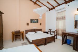 a bedroom with a bed and a table and chairs at Surf Range in Matara