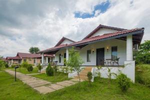a white house with a porch and a lawn at TULI VEER BAGH RESORT TURIA in Khawāsa