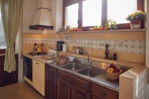 a kitchen with a sink and a stove and windows at Le Balze Appartamenti in Perugia
