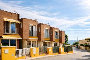a row of brick apartment buildings on a street at Beach Blessing in Isla Plana