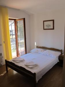 1 dormitorio con 1 cama con sábanas blancas y ventana en Apartments and Rooms Degenija, en Starigrad-Paklenica