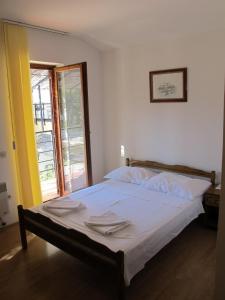 a bedroom with a bed with white sheets and a window at Apartments and Rooms Degenija in Starigrad-Paklenica