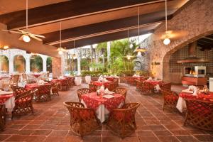 a dining room with red tables and chairs at El Cid Granada Hotel & Country Club in Mazatlán