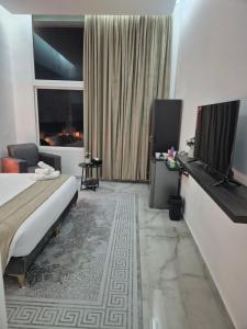 a hotel room with a bed and a flat screen tv at Malaga palace in Soûr