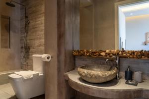 a bathroom with a stone sink and a toilet at Core Luxury Suites in Skiathos +126 photos