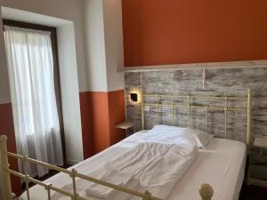 a bed in a bedroom with a brick wall at HOTEL GARNI BARANCIO - Auronzo center in Auronzo di Cadore +4 photos
