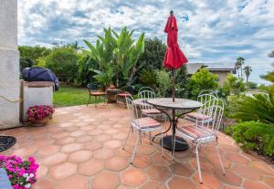 a patio with a table and chairs and an umbrella at Kate Stanton Inn in Encinitas