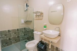 a bathroom with a sink and a toilet and a mirror at Serenity Busay Room 2 in Cebu City