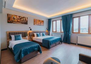 a hotel room with two beds with blue sheets at City Port Hotel Trabzon in Trabzon