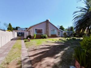 a house with a palm tree in the yard at PrimeStay One 2 Bedroom Apartment in Johannesburg