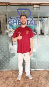 a man standing in front of a glass door at Sheetal Dormitory in Mumbai