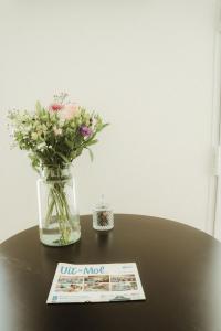 a vase of flowers sitting on a table with a newspaper at De Wilden Ezel in Mol