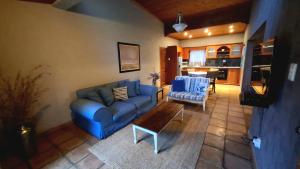 a living room with a blue couch and a table at Butlers Crown in Klerksdorp