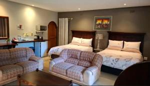 a living room with two beds and a couch at Butlers Crown in Klerksdorp