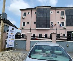 a car parked in front of a pink building at Fimdah Hotel in Dushepe