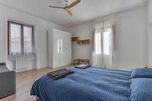 a bedroom with a blue bed with a ceiling fan at A Casa di Nonna Anna in Porto Azzurro