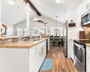 a kitchen with white cabinets and a dining room at Bailey Beach House Beach Views in Freeport
