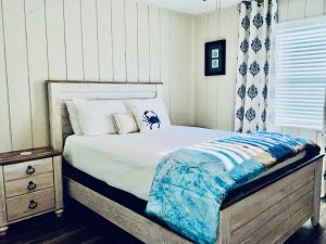 a bedroom with a bed with a wooden frame and a night stand at Bailey Beach House Beach Views in Freeport