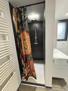 a shower curtain in a bathroom with a cross on the wall at Maison Floréal Giverny in Giverny +37 photos