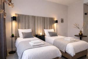a bedroom with two beds with white sheets at Vibrant Raamsdonksveer, near Efteling & Biesbosch in Raamsdonksveer