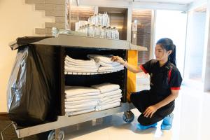 Eine Frau sitzt neben einem Regal mit Handtüchern. in der Unterkunft Ps Sriphu Hotel in Hat Yai + 138 Fotos