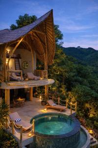 a villa with a swimming pool and a resort at Green Poya - Luxury Eco Bambu Resort in South Lombok in Selong Belanak