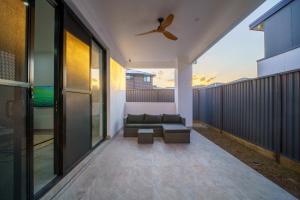 a balcony with a couch and a ceiling fan at Brand New Elegant House in Marsden Park