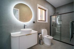 a bathroom with a sink and a toilet and a mirror at Brand New Elegant House in Marsden Park +10 photos
