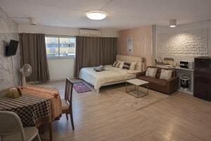 a bedroom with a bed and a couch and a table at IMPACT popular condo c5 แม่ตังค์ in Ban Bang Phang