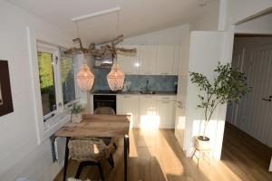 a kitchen with a wooden table in a room at Tussen duin en dijk in Warmenhuizen