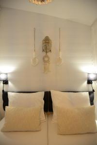a bed with two pillows and a clock on the wall at Tussen duin en dijk in Warmenhuizen