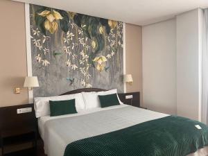 a bedroom with a large bed with a floral wall mural at Hotel Villa de Biar in Biar