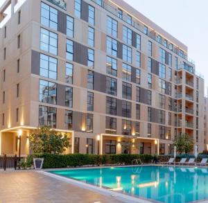 an apartment building with a pool in front of it at Modern studio Al mamsha by Alef in Sharjah