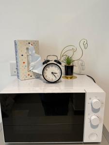 a clock sitting on top of a microwave at Modern studio Al mamsha by Alef in Sharjah +4 photos
