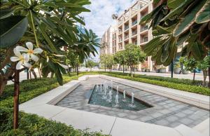 a fountain in the middle of a courtyard with a building at Modern studio Al mamsha by Alef in Sharjah