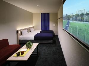 a hotel room with a bed and a couch and a tv at Minn STATION Ai Nagoya in Aoichō +9 photos