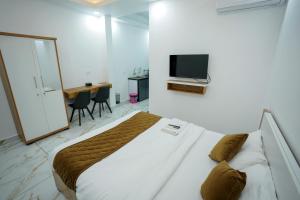 a bedroom with a bed and a tv on the wall at Hotel The Mountmist in Kakkanad