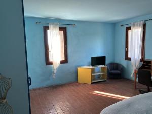 a room with blue walls and a tv and a chair at B&B La Piuma in Castellaccio