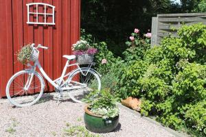 a bike parked next to a red building with flowers at Holthus in Kollmar