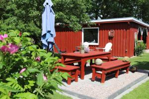 a picnic table and bench in front of a red shed at Holthus in Kollmar