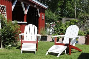 two chairs and a table in front of a red shed at Holthus in Kollmar +61 photos