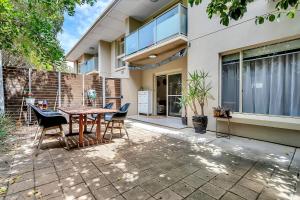 a patio with a table and chairs in front of a house at Secure Suite in Gated Complex, Courtyard, 5 Min CBD in Rose Park