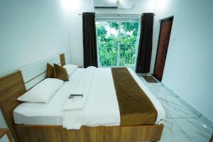 a bedroom with a large bed with a window at Hotel The Mountmist in Kakkanad